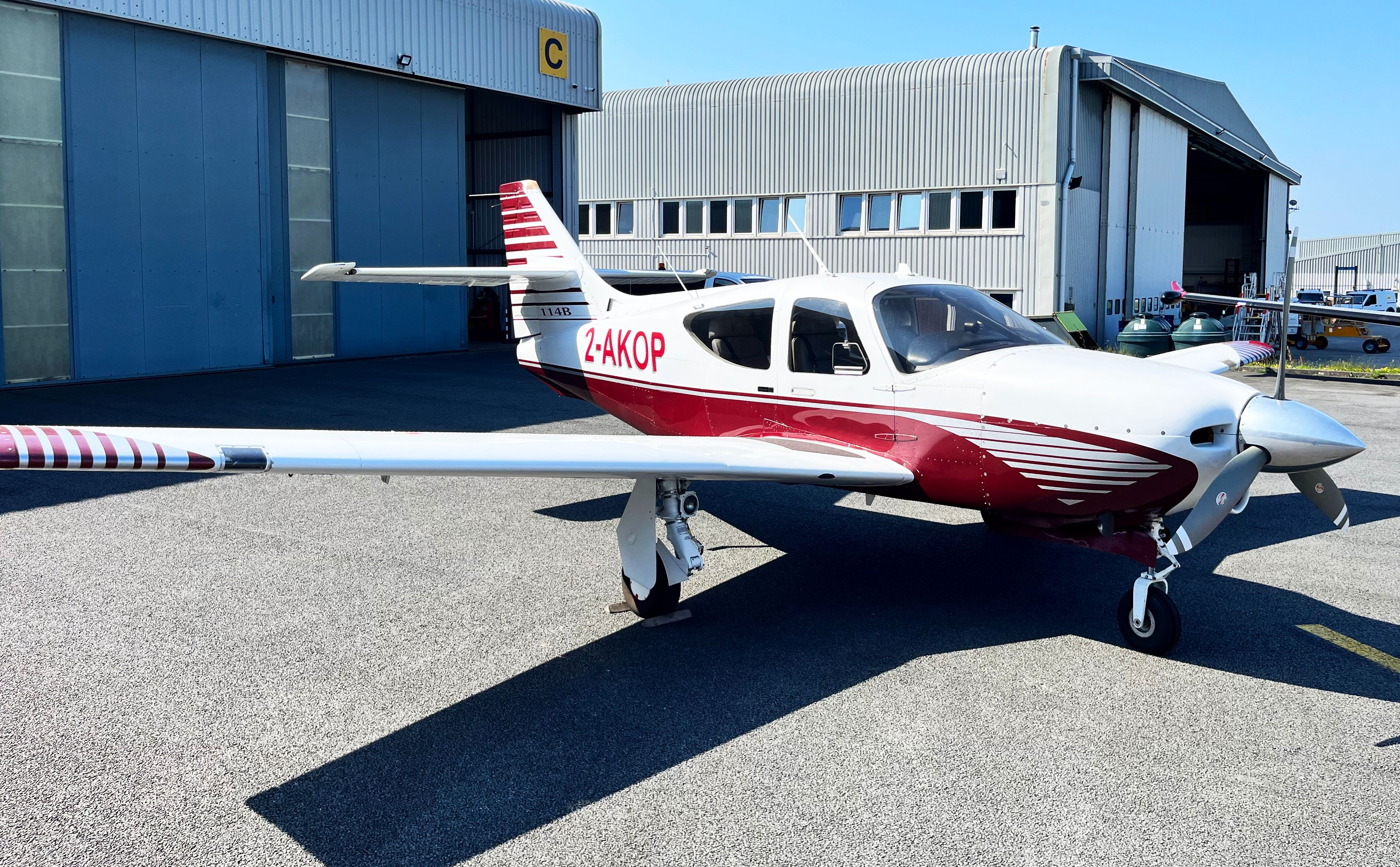 A white and red aircraft is parked on the tarmac.